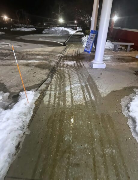 Brine pre-treated commercial sidewalk at night in Nashua, NH by NorthShire
