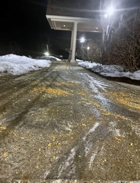 Treated salt spread on a commercial sidewalk at night in southern NH by NorthShire